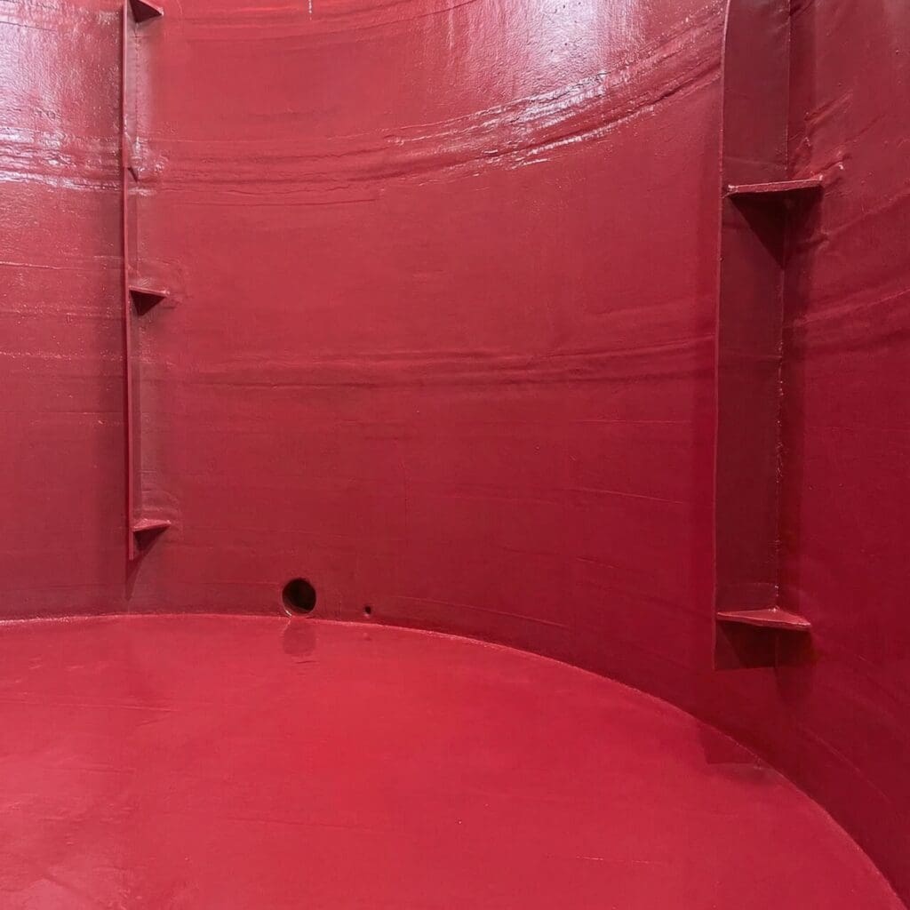 Industrial storage tank interior with red protective coating after rehabilitation